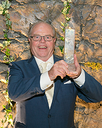 man holding up award